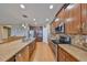 Kitchen with stainless steel appliances, granite countertops, wooden cabinets, and a view to an adjacent space at 1510 Yale Castle Ct, Ruskin, FL 33570