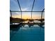 Relaxing screened pool reflecting a colorful sunset over the serene lake at 1510 Yale Castle Ct, Ruskin, FL 33570