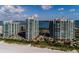 Stunning aerial view of beachfront high-rise condos with pools and lush landscaping, showcasing luxury living at 1560 Gulf Blvd # 1104, Clearwater Beach, FL 33767