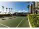 Outdoor basketball court with pristine surface, surrounded by palm trees and landscaping at 1560 Gulf Blvd # 1104, Clearwater Beach, FL 33767