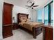 Bright bedroom featuring a large bed, ceiling fan, and stunning ocean views from the large window at 1560 Gulf Blvd # 1104, Clearwater Beach, FL 33767