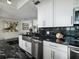 Modern kitchen with stainless steel appliances, black marble counters, and white cabinets offers a sleek design at 1560 Gulf Blvd # 1104, Clearwater Beach, FL 33767