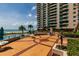 Expansive patio area with in-ground pool, ocean views and surrounding lush landscaping at 1560 Gulf Blvd # 1104, Clearwater Beach, FL 33767