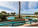 Beautiful in-ground pool surrounded by palm trees and lush landscaping, with scenic beach views at 1560 Gulf Blvd # 1104, Clearwater Beach, FL 33767