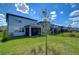 Backyard with green grass, a black metal fence, and neighboring houses under a bright sky at 17805 Everlong Dr, Land O Lakes, FL 34638