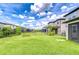 Expansive backyard featuring lush green grass, a black metal fence, and a distant playset at 17805 Everlong Dr, Land O Lakes, FL 34638