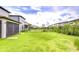 Spacious backyard with manicured lawn, black metal fence, and neighboring homes in the background at 17805 Everlong Dr, Land O Lakes, FL 34638
