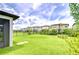 View of a home's backyard with a green lawn, fence, and neighboring houses at 17805 Everlong Dr, Land O Lakes, FL 34638