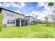 View of the backyard featuring a screened-in porch and a well-manicured lawn at 17805 Everlong Dr, Land O Lakes, FL 34638