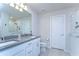 Bright bathroom featuring double sinks with gray counters and a walk-in shower with white subway tile at 17805 Everlong Dr, Land O Lakes, FL 34638