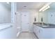 Modern bathroom featuring tiled floors, double sinks, white cabinets, and a walk-in shower at 17805 Everlong Dr, Land O Lakes, FL 34638