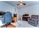 Well-lit bedroom featuring a ceiling fan, comfortable chair, and a dedicated gaming setup at 17805 Everlong Dr, Land O Lakes, FL 34638