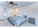 The well-lit bedroom features a ceiling fan, soft carpet, window, and gray dresser, perfect for any homeowner at 17805 Everlong Dr, Land O Lakes, FL 34638