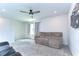 Upstairs bonus room featuring neutral carpet, a ceiling fan, and comfortable couch at 17805 Everlong Dr, Land O Lakes, FL 34638