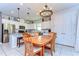 Beautiful open-concept dining area adjacent to kitchen, featuring a modern chandelier and white cabinetry at 17805 Everlong Dr, Land O Lakes, FL 34638