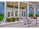 Inviting clubhouse entrance with stairs, lush plants, and double glass doors at 17805 Everlong Dr, Land O Lakes, FL 34638