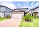 Charming home with a two-car garage, brick driveway, and manicured landscaping at 17805 Everlong Dr, Land O Lakes, FL 34638