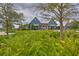 Community building with blue siding, a metal roof, white trim, and surrounding mature landscaping at 17805 Everlong Dr, Land O Lakes, FL 34638