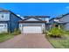 Charming home with a brick driveway and walkway surrounded by lush landscaping and green grass at 17805 Everlong Dr, Land O Lakes, FL 34638