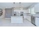 Bright kitchen featuring white cabinets, stainless steel appliances, island with gray counter and tile flooring at 17805 Everlong Dr, Land O Lakes, FL 34638