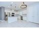 Bright kitchen featuring white cabinets, stainless steel appliances, island with light pendants and tile flooring at 17805 Everlong Dr, Land O Lakes, FL 34638
