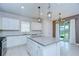 Bright kitchen featuring white cabinets, stainless steel appliances, gray counter tops, tile flooring and island at 17805 Everlong Dr, Land O Lakes, FL 34638