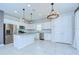 Bright kitchen featuring white cabinets, stainless steel appliances, island with light pendants and tile flooring at 17805 Everlong Dr, Land O Lakes, FL 34638
