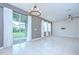 Bright living room with tile flooring, a modern chandelier, and sliding glass doors at 17805 Everlong Dr, Land O Lakes, FL 34638