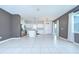Open-concept layout with modern kitchen, dining, and living area featuring tile flooring at 17805 Everlong Dr, Land O Lakes, FL 34638