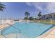 Community pool featuring clear blue water, a secure perimeter fence, and comfortable lounge seating at 1868 Shore S Dr # 411, South Pasadena, FL 33707