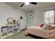 Cozy bedroom with soft pink bedding, decorative vines, and a ceiling fan for added comfort at 2153 Broadway View Ave, Brandon, FL 33510