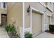 Close-up of a townhome's exterior, highlighting the front door, garage, and well-maintained garden at 2153 Broadway View Ave, Brandon, FL 33510