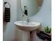 Cozy powder room features a pedestal sink, round mirror, and decorative accents at 2153 Broadway View Ave, Brandon, FL 33510