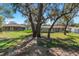 View of backyard with mature trees and green grass at 2156 Deltona Blvd, Spring Hill, FL 34606