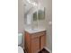 Bathroom vanity with wooden cabinet, white countertop, mirror, and lighting at 2156 Deltona Blvd, Spring Hill, FL 34606