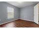 Bedroom featuring wood-look floors, gray paint, and natural light from the window at 2156 Deltona Blvd, Spring Hill, FL 34606