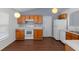 Well-lit kitchen featuring white appliances, wood cabinets, and hard surface countertops at 2156 Deltona Blvd, Spring Hill, FL 34606