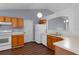 Open kitchen featuring white appliances, wood cabinets, and a view into the living room at 2156 Deltona Blvd, Spring Hill, FL 34606