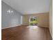 Bright living room with laminate flooring, vaulted ceiling, and sliding glass door at 2156 Deltona Blvd, Spring Hill, FL 34606