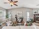 Bright and airy living room featuring vaulted ceilings, fireplace, ceiling fan and neutral decor at 2297 Citrus Hill Rd, Palm Harbor, FL 34683