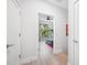 Bright hallway with wood-look flooring leading to a bedroom with a large window overlooking trees at 2705 N Boulevard # 2, Tampa, FL 33602