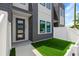 Inviting entrance with modern door, artificial turf, and white fence creating a welcoming outdoor space at 2808 N Florida Ave, Tampa, FL 33602
