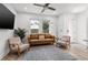 Cozy living room with a ceiling fan, two comfy chairs, a leather sofa, a gray rug, and a flatscreen TV at 2808 N Florida Ave, Tampa, FL 33602