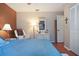 Cozy bedroom featuring hardwood floors, bedside lamps, and a white dresser with nautical decor at 3416 Fairfield Trl, Clearwater, FL 33761
