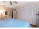 Cozy bedroom showcasing hardwood floors, a white dresser, and a spacious closet with bi-fold doors at 3416 Fairfield Trl, Clearwater, FL 33761