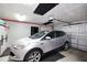 A well-lit garage featuring a silver SUV, finished walls, and an automatic garage door opener at 3416 Fairfield Trl, Clearwater, FL 33761