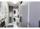 Convenient laundry room with a stacked washer and dryer, storage cabinets, and a utility sink at 3416 Fairfield Trl, Clearwater, FL 33761