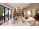 Cozy living room featuring a stone fireplace, white tile floors, and access to patio at 3416 Fairfield Trl, Clearwater, FL 33761