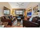 Living room with hardwood floors, brown leather seating, a ceiling fan, and a decorative rug at 3416 Fairfield Trl, Clearwater, FL 33761