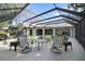 Screened-in patio with seating, a table, and views of the pool and lush backyard at 3416 Fairfield Trl, Clearwater, FL 33761